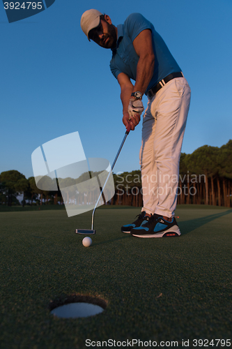 Image of golfer  hitting shot at golf course