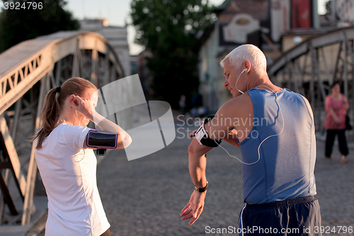 Image of jogging couple planning running route  and setting music