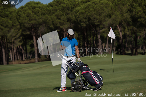 Image of golf player walking with wheel bag