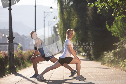 Image of couple warming up and stretching before jogging