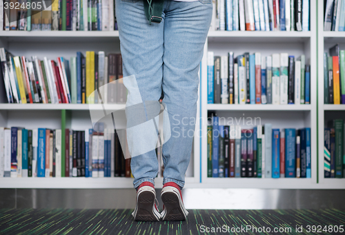 Image of famale student selecting book to read in library