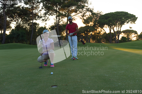 Image of couple on golf course at sunset