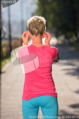 Image of jogging woman setting phone before jogging