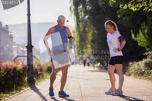 Image of jogging couple planning running route  and setting music