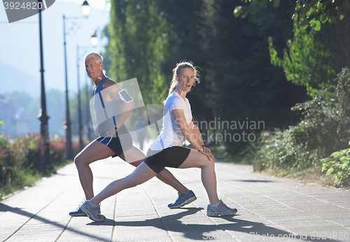 Image of couple warming up and stretching before jogging