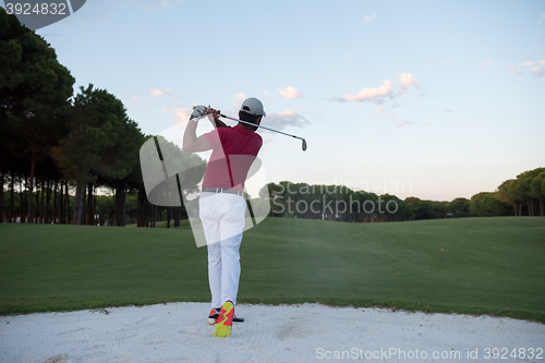 Image of golfer hitting a sand bunker shot on sunset