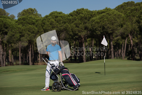 Image of golf player walking with wheel bag
