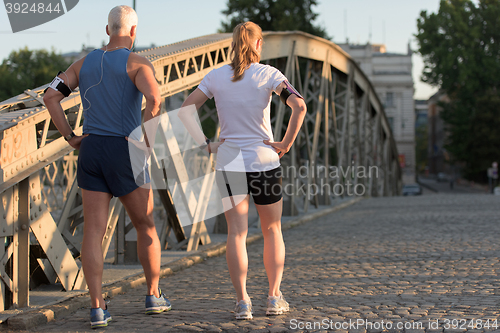 Image of jogging couple planning running route  and setting music