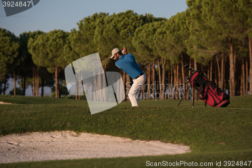 Image of golfer hitting a sand bunker shot on sunset