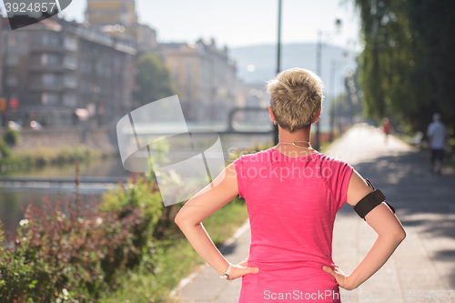 Image of jogging woman setting phone before jogging