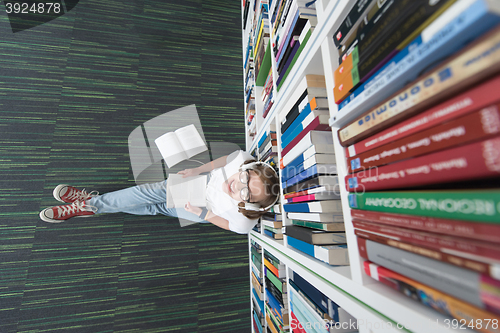 Image of female student study in library, using tablet and searching for 