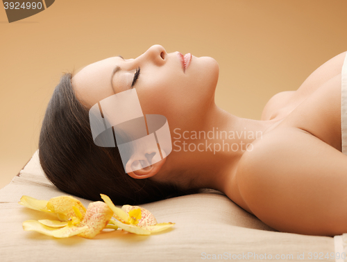 Image of woman in spa salon lying on the massage desk