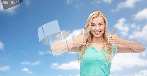 Image of happy woman or teenage girl showing thumbs up