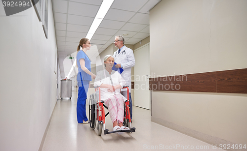 Image of medics and senior woman in wheelchair at hospital