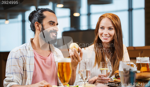 Image of friends dining and drinking beer at restaurant