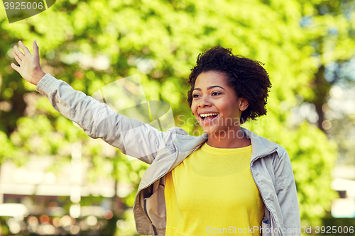 Image of happy african american young woman in summer park