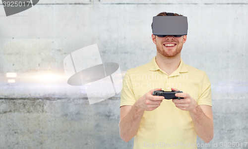 Image of man in virtual reality headset and gamepad playing