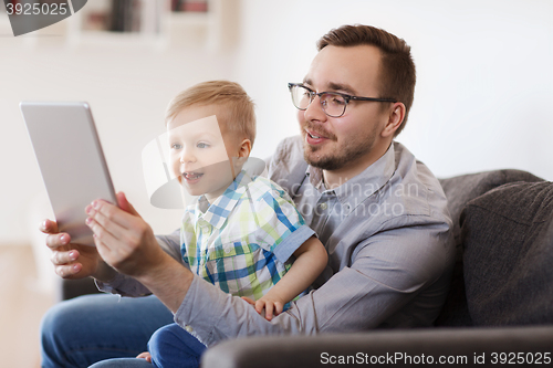 Image of father and son with tablet pc playing at home
