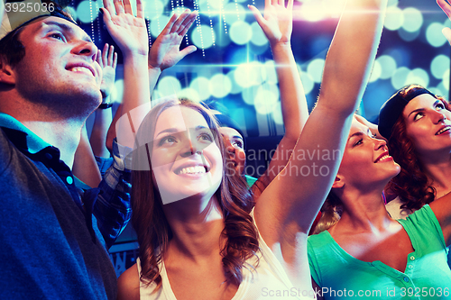 Image of smiling friends at concert in club