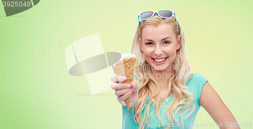 Image of happy young woman in sunglasses eating ice cream