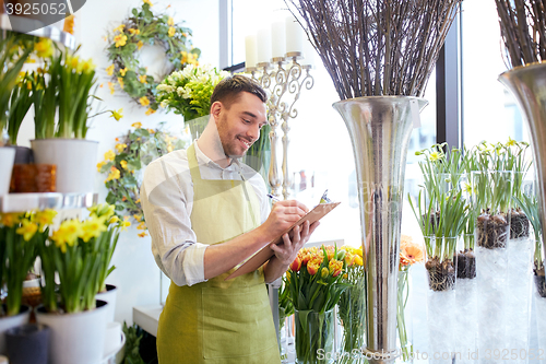 Image of florist man with clipboard at flower shop