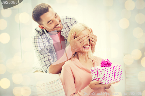 Image of happy man giving woman gift box at home