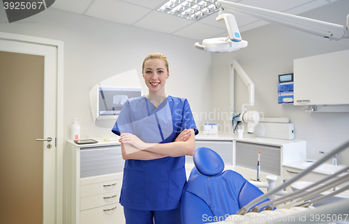 Image of happy young female dentist at dental clinic office