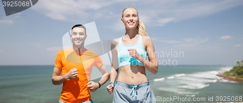 Image of happy couple running over sea or beach background