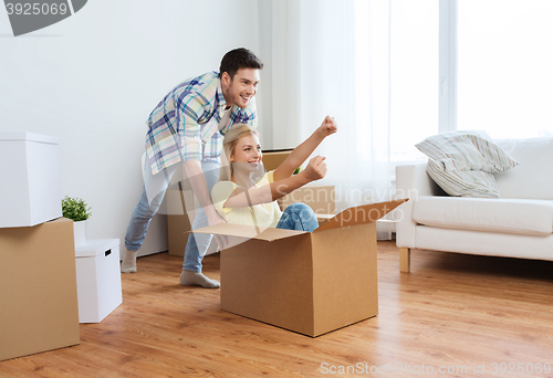 Image of happy couple having fun with boxes at new home