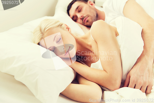 Image of happy couple sleeping in bed at home