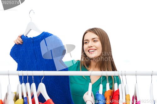 Image of happy woman choosing clothes at home wardrobe