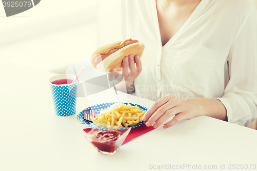 Image of close up of woman eating hotdog and french fries