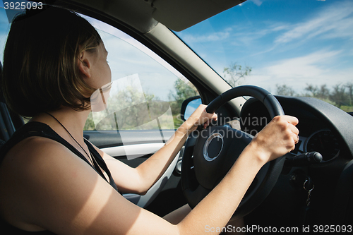 Image of the girl goes behind the wheel of a car