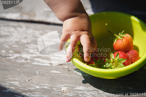 Image of girl takes a strawberry