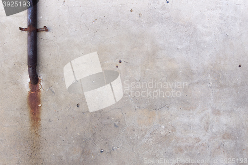 Image of wall with a rusty pipe