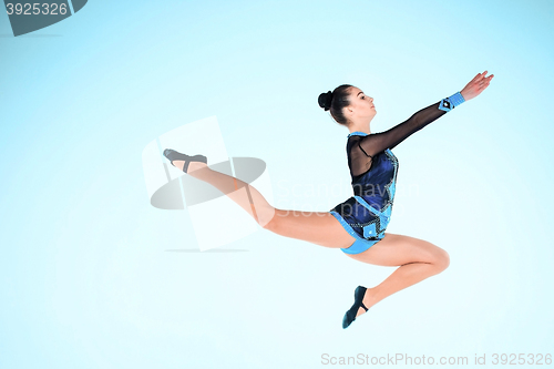 Image of The girl doing gymnastics dance on a blue background