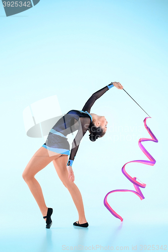 Image of The girl doing gymnastics dance with colored ribbon on a blue background