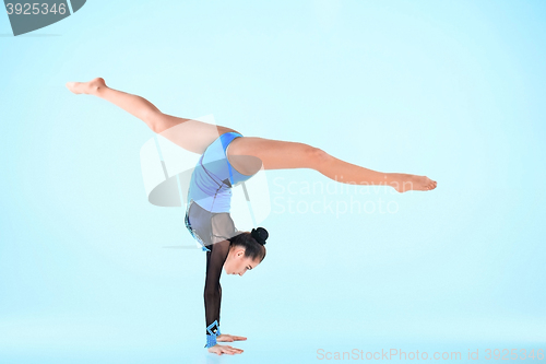 Image of The girl doing gymnastics dance on a blue background