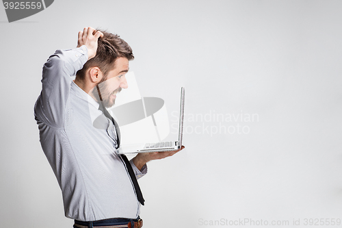 Image of The young surprised man with his laptop computer