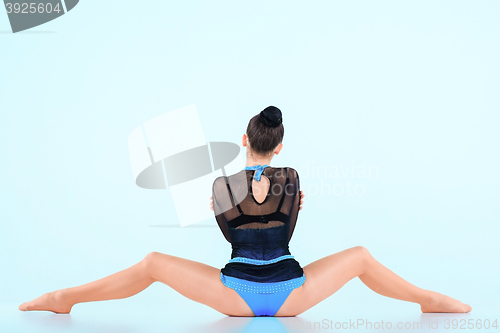 Image of The girl doing gymnastics dance on a blue background