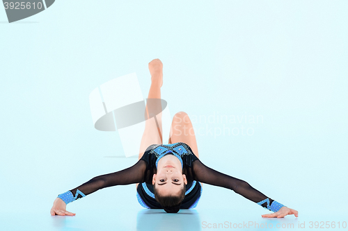 Image of The girl doing gymnastics dance on a blue background