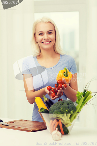 Image of smiling young woman cooking vegetables at home