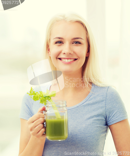 Image of smiling woman drinking juice or shake at home