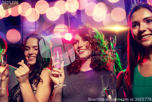 Image of smiling friends with glasses of champagne in club