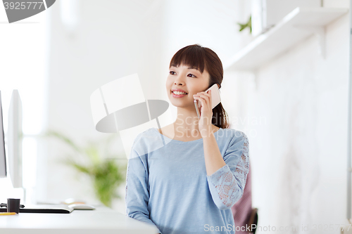 Image of businesswoman calling on smartphone at office