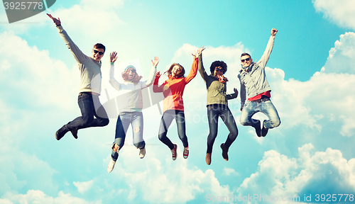 Image of smiling friends in sunglasses jumping high