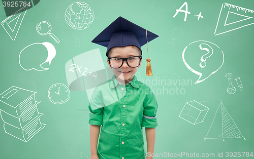 Image of boy in bachelor hat and eyeglasses over blackboard