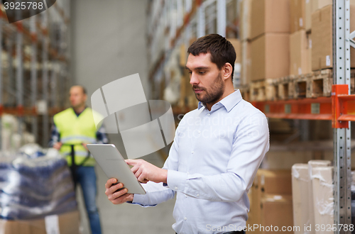 Image of businessman with tablet pc at warehouse