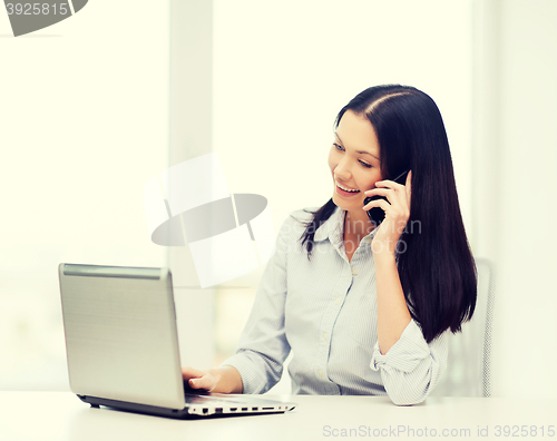 Image of businesswoman with laptop and cell phone