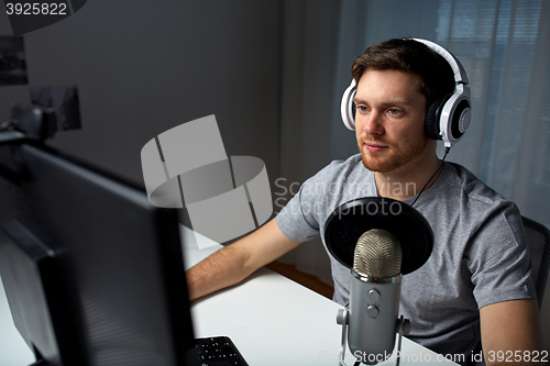 Image of man in headset playing computer video game at home